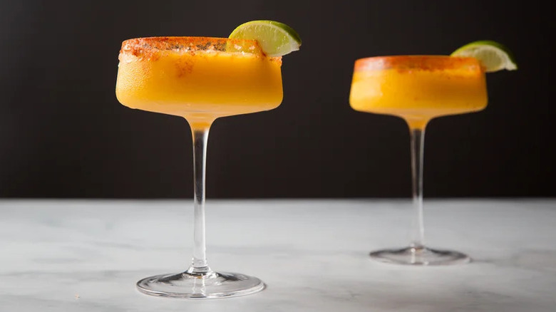 Sip-Worthy Frozen Mango Margaritas in coupe glasses with lime wedges