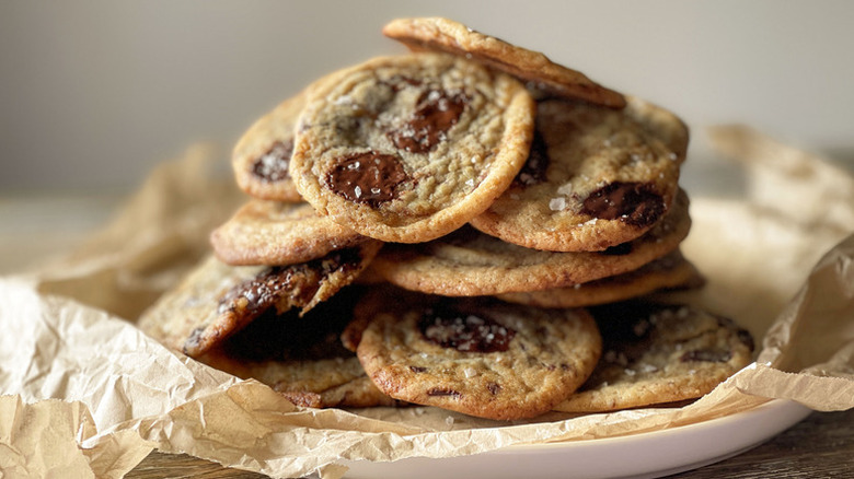 Pile of chocolate chip cookies on parchment-lined plate