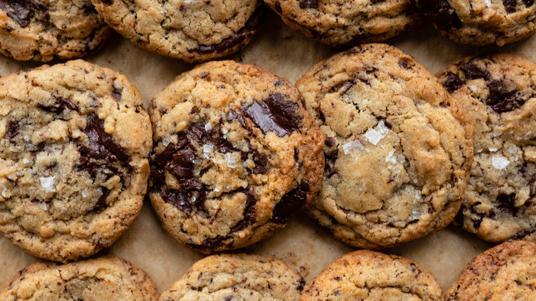 Top down view of chocolate chip cookies lined up on parchment paper