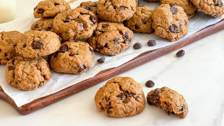 Vegan chocolate chip cookies on parchment-lined wooden board