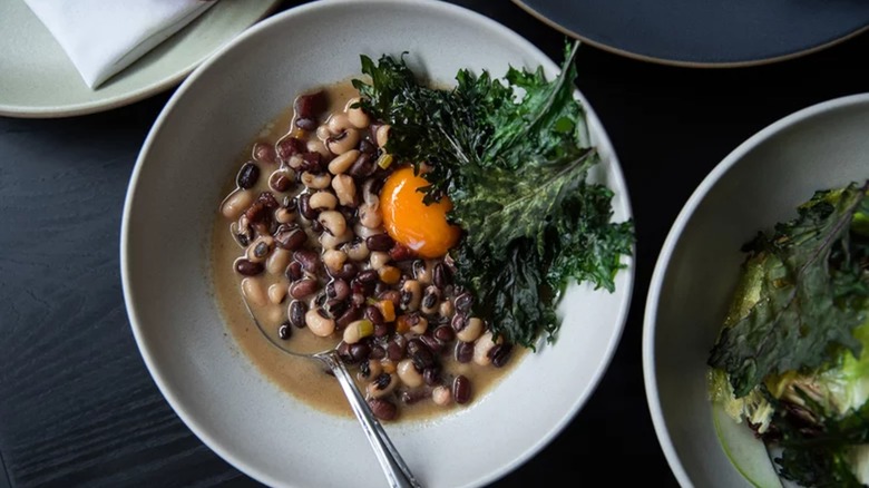 Bowl of black-eyed peas, confit egg yolk, and crispy collards