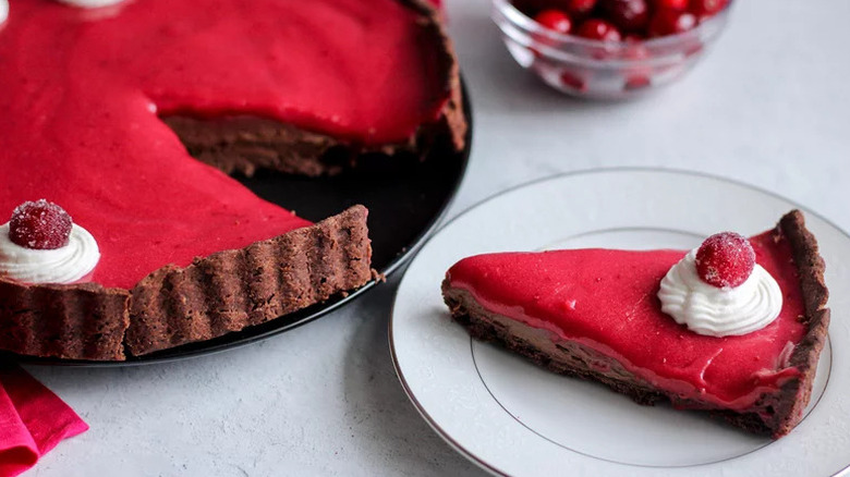 Slice of Chocolate Cranberry Curd Tart on white plate