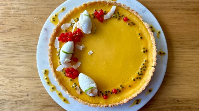 Tropic Holiday Passion Fruit Tart on white plate on wooden table