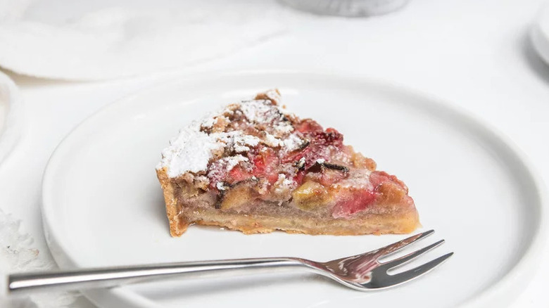 Slice of Strawberry Rhubarb Custard Tart on white plate
