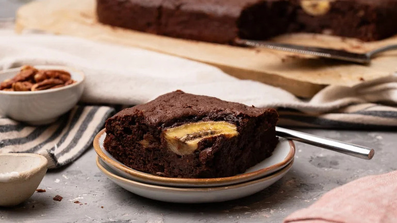 Banana Pecan Brownies on beige plate with utensil