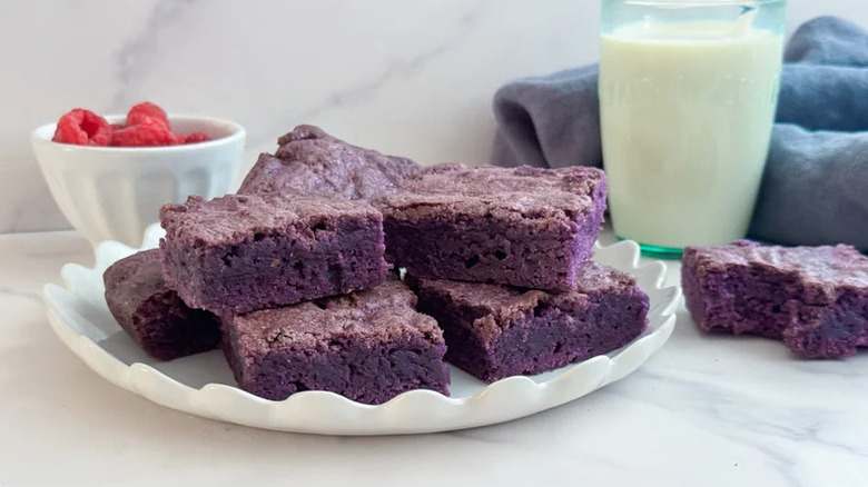 Fudgy Ube Brownies on white plate with glass of milk