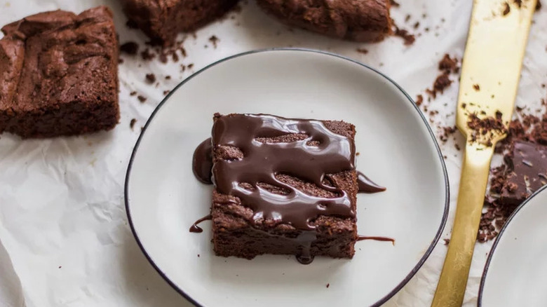 Gooey Brownies with chocolate drizzle on white plate