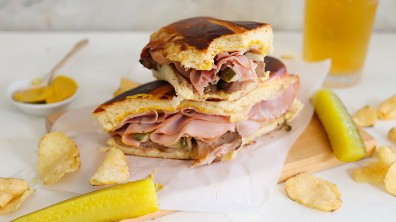 Cuban sandwich surrounded by chips and pickles