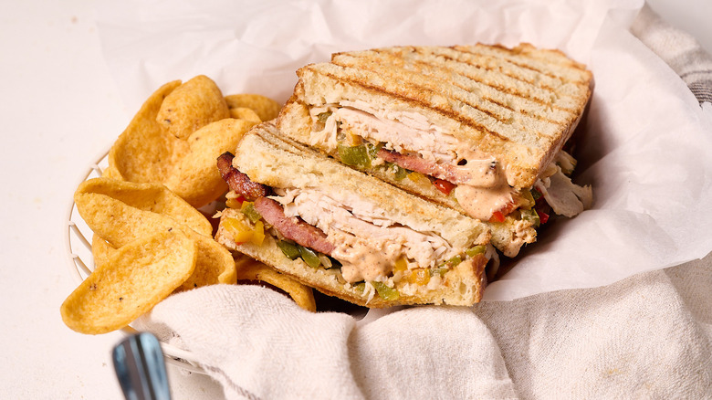Turkey po'boy panini with chips in basket