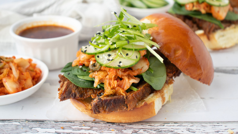 Korean bulgogi sandwich topped with cucumber, kimchi, and scallions