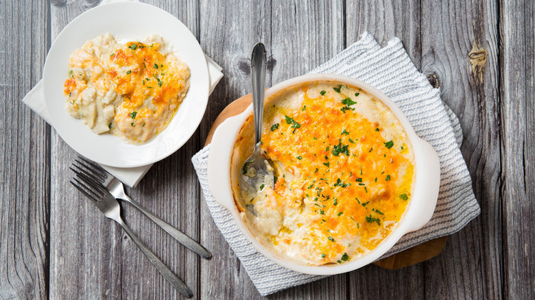 Potatoes au gratin in baking dish and served onto plate