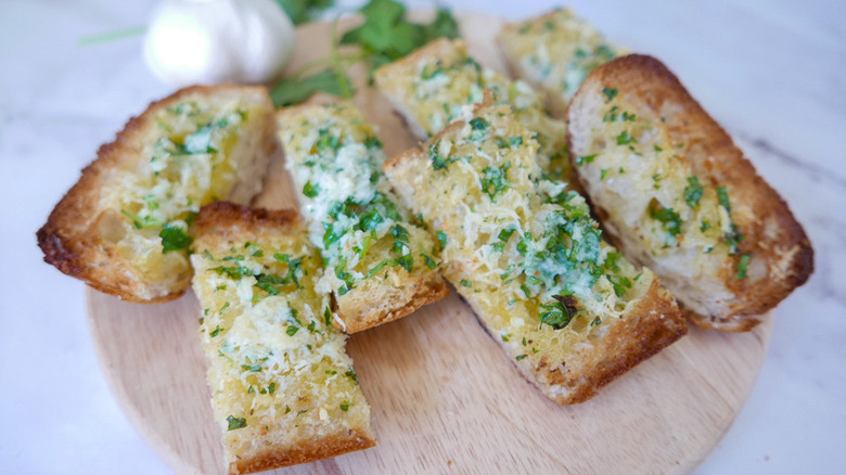 Sliced garlic bread on wooden board