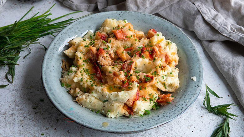 Lobster mashed potatoes in blue bowl, topped with chopped chives