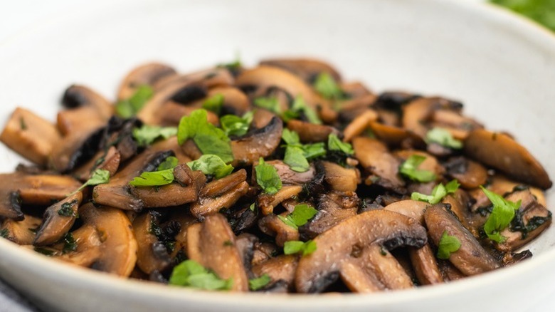 Sauteed mushrooms on bowl, topped with fresh parsley