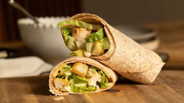 Easy Chicken Caesar Wrap with Homemade Croutons stacked on wooden cutting board