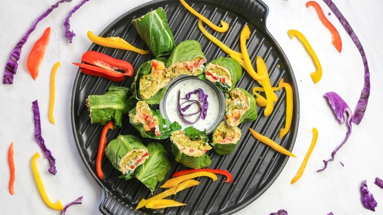 Simple Collard Wrap arranged on black dish surrounded by vegetables