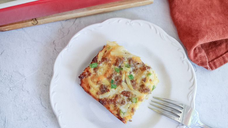 Slice of cheesy sausage breakfast casserole on plate