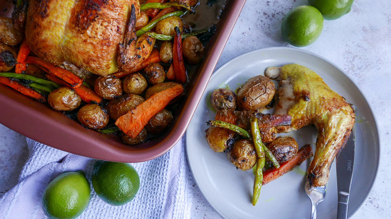 Spiced roast chicken and vegetables served onto plate