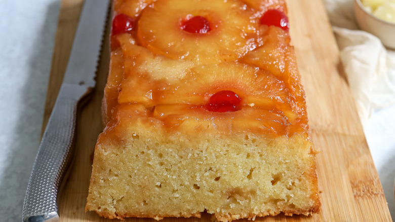 Pineapple upside-down loaf cake on wooden cutting board