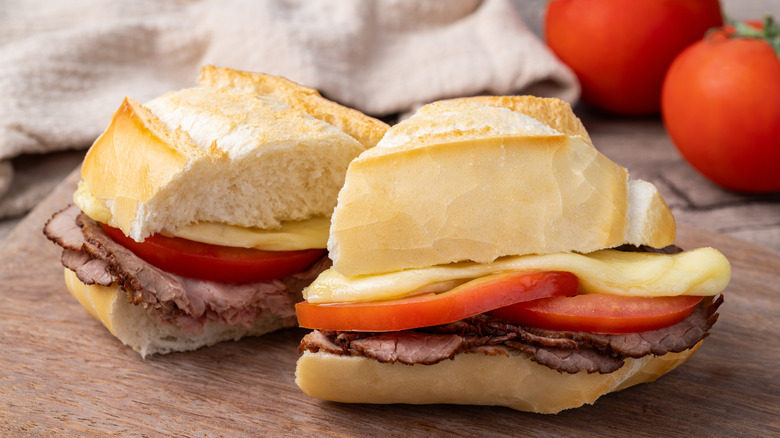 Bauru sandwich with roast beed, tomatoes, and mozarella on wooden board