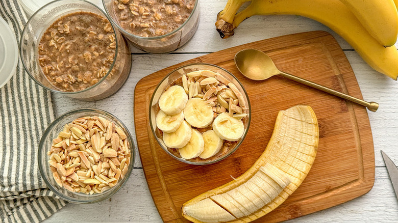 Overnight oats in glasses, topped with sliced banana and slivered almonds