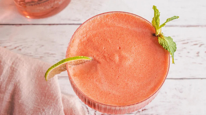 Creamy Frozen Watermelon Cocktail with sprig of mint and lime wedge