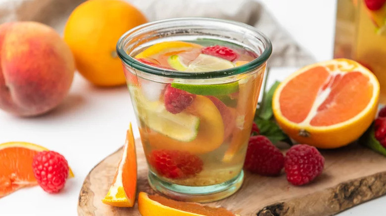 Floral White Wine Sangria in thick glass on wooden cutting board