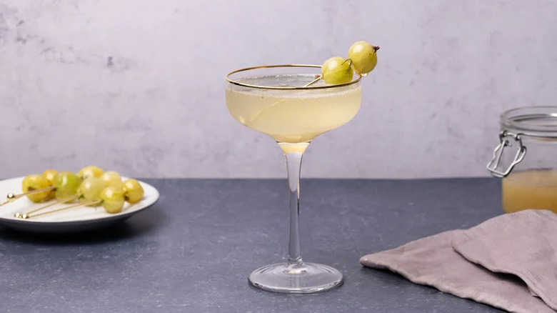 Gooseberry Fizz Cocktail in coupe glass with gooseberry garnish