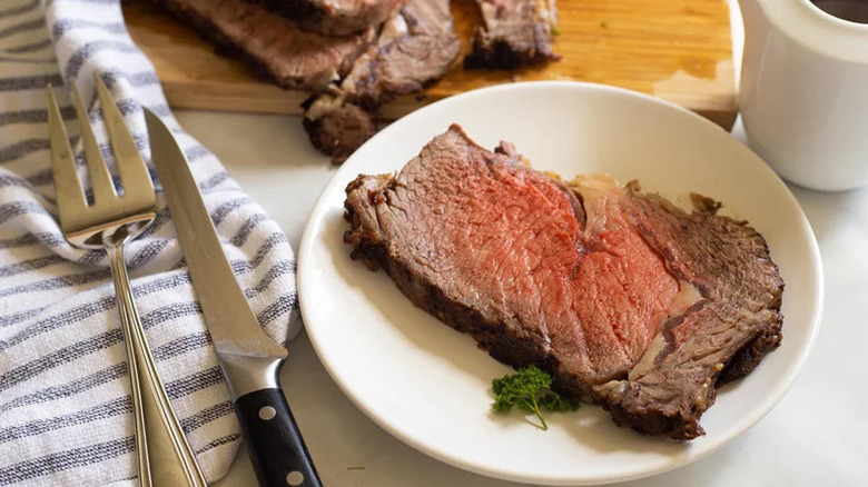 Instant Pot Prime Rib on white plate with fork and knife