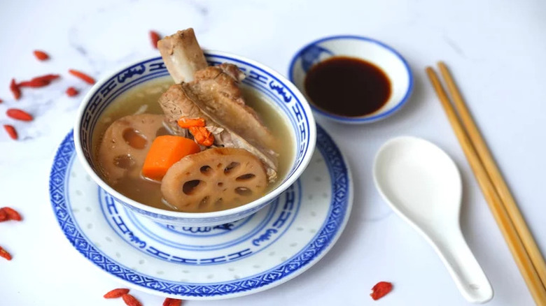 Lotus Root Pork Rib Soup in blue and white bowl with sauce on side