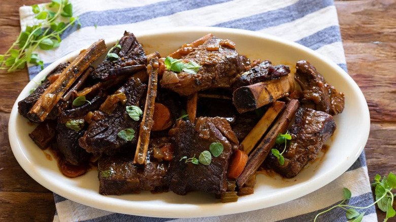 Red Wine Braised Short Ribs on white oval plate with herbs