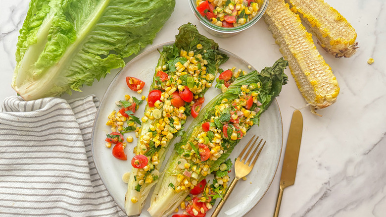 Corn and tomato salad serving in grilled romaine lettuce leaves