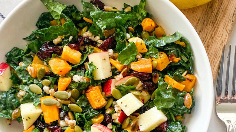 Butternut squash, kale, and apple salad in white bowl