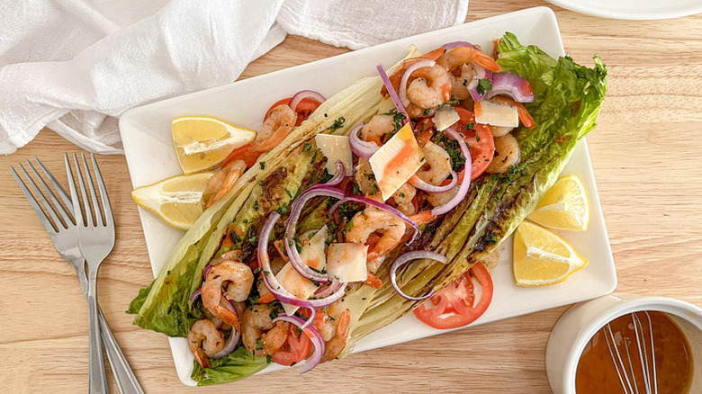 Spicy shrimp salad served in large lettuce leaves on white platter