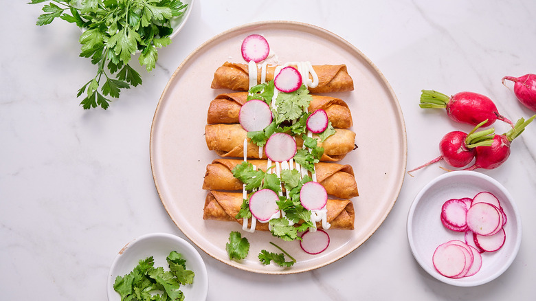 flautas with toppings on a plate