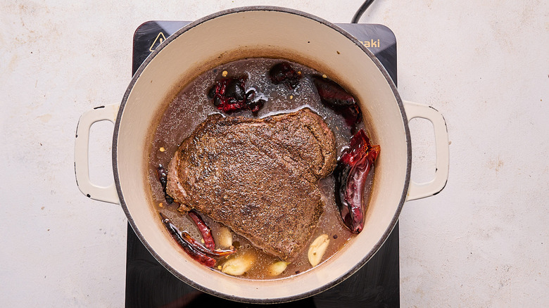 beef and chiles in a pot with beef broth