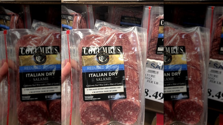 Hand holding package of Columbus Italian dry salame