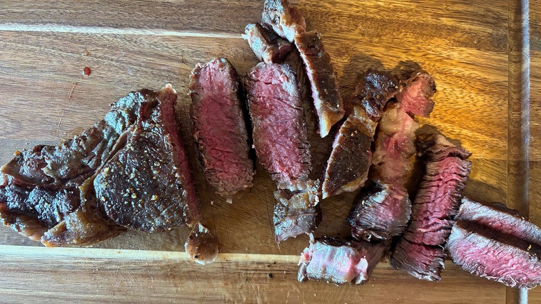 Top-down shot of sliced steak on cutting board
