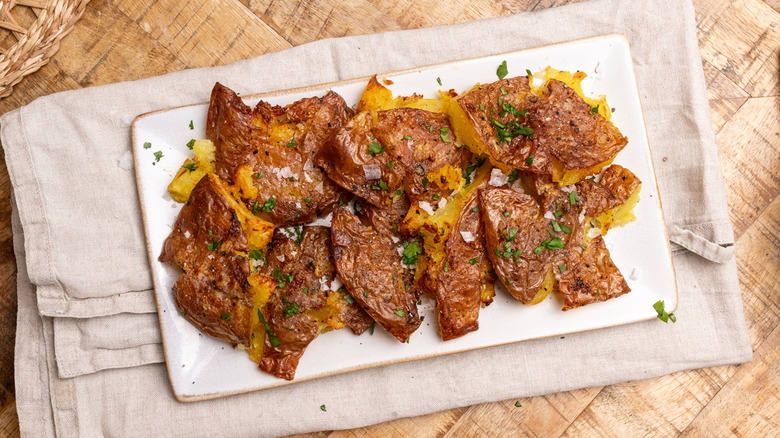 air-fried garlic smashed potatoes on a white plate over a cloth