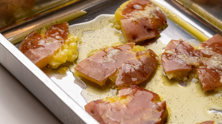 smashed potatoes drizzled with garlic butter in a tray