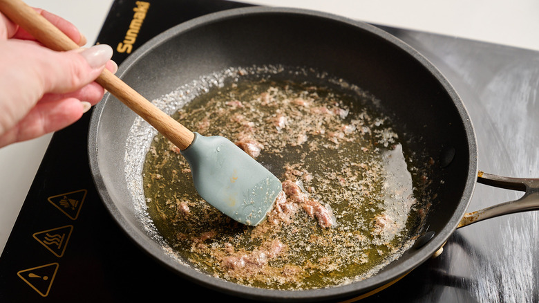 melting anchovies in skillet with spatula