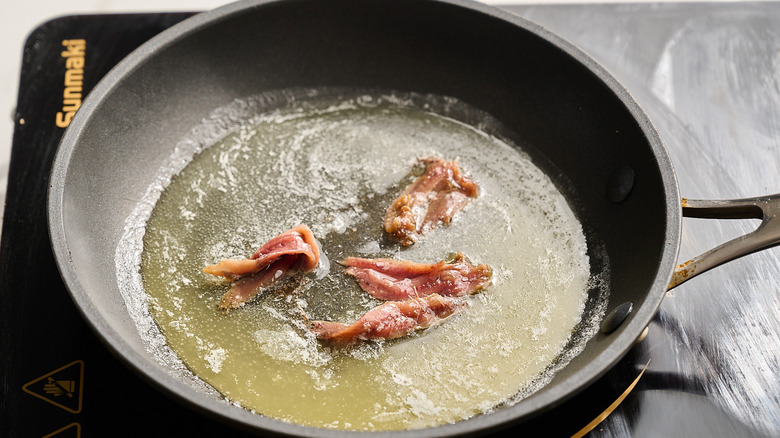 anchovies cooking in a skillet