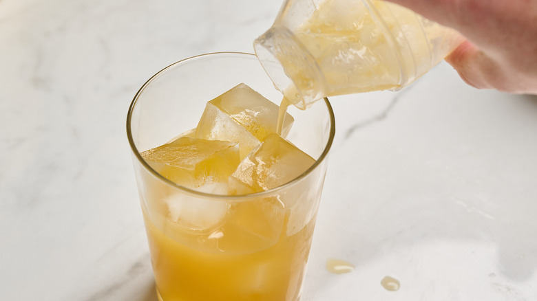 straining cocktail over ice