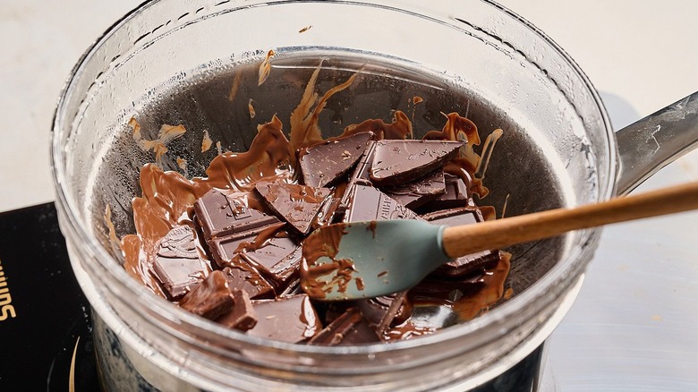 Chocolate squares melting in bowl over double boiler