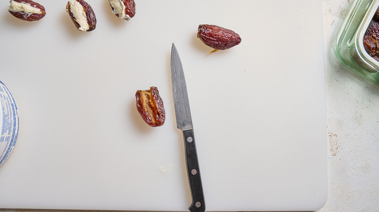 Dates and knife on cutting board