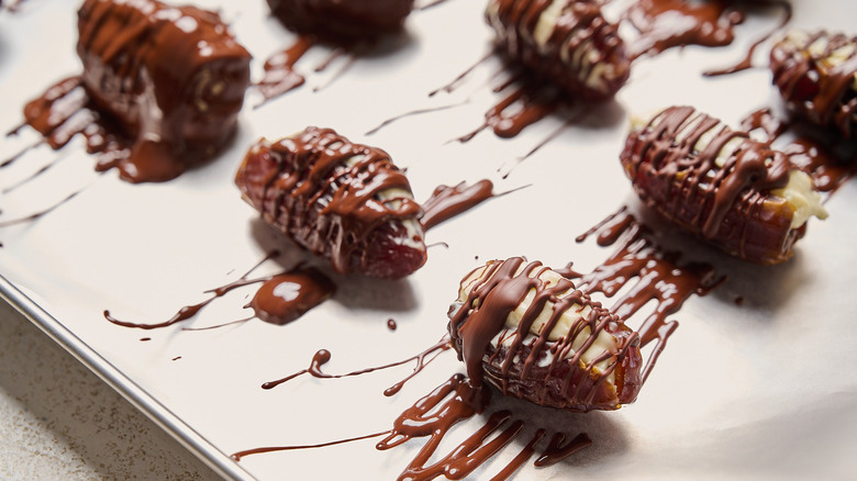 chocolate covered dates on a sheet tray