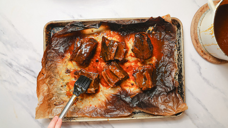 Brushing ribs with sauce