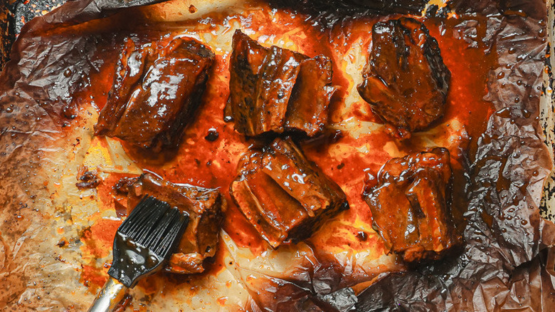 Brushing ribs with sauce