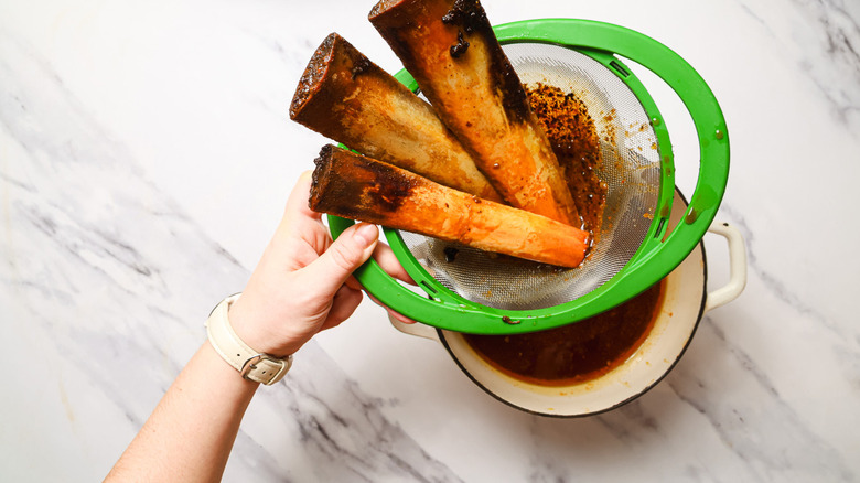 Straining short ribs through colander