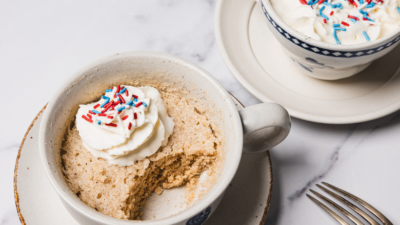 Two vanilla mug cakes in white cups